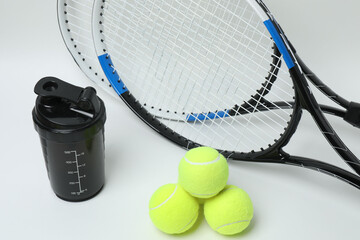 Tennis racket, sports bottle and ball on white background