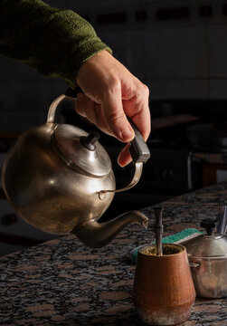 Cebando mate argentino en la cocina con antigua pava