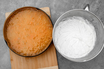 Bita śmietana i galaretka pomarańczowa z brzoskwiniami, przygptowane warstwy do ciasta