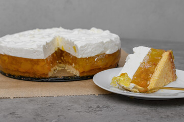 Cake with peach and orange fruit jelly decorated with a layer of sweet whipped cream