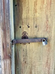 Weathered and aged wooden door with vintage rustic panel design in a country house or cabin exterior. Textured wooden grain and worn surface. Finland, 19th century