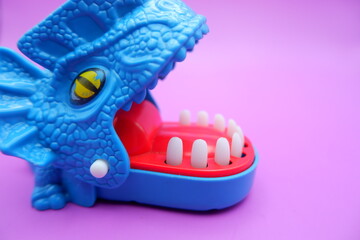 Blue Dinosaur Bite Game Toy on Pink Background