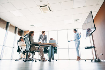 Creative business team collaborating during a focused presentation meeting in a modern corporate...