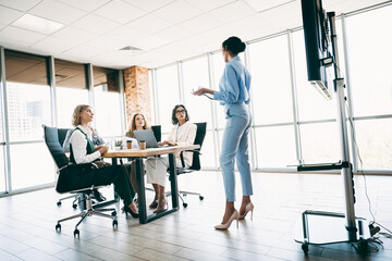 Professional business meeting with diverse team collaborating in modern office workspace motivated...