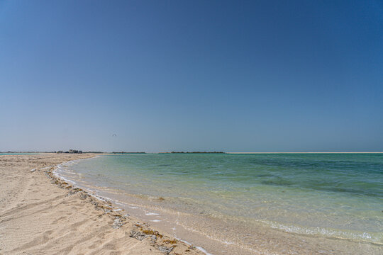Peaceful beach scene near Al Fuwairit in Al Shamal, Qatar, featuring clear turquoise waters, soft sand, and a wide blue sky - a scenic coastal escape in the northern Gulf region.

