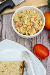 Preparing fresh guacamole with rustic bread and tomatoes