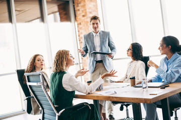 Young professionals collaborating during a business meeting in modern office setting, showcasing...