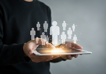 A man holds a tablet displaying a network of people icons