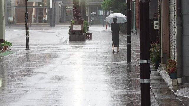 観光名所高山市の街並みで歩く若い女性と猛烈な雨の風景