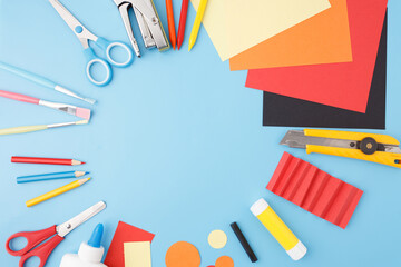 Craft supplies on blue table ready for use in school projects, DIY tutorials, educational content,...