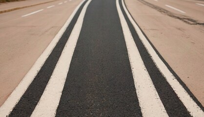 A Grainy blacktop with evenly spaced cream lines, a clean and understated street aesthetic.