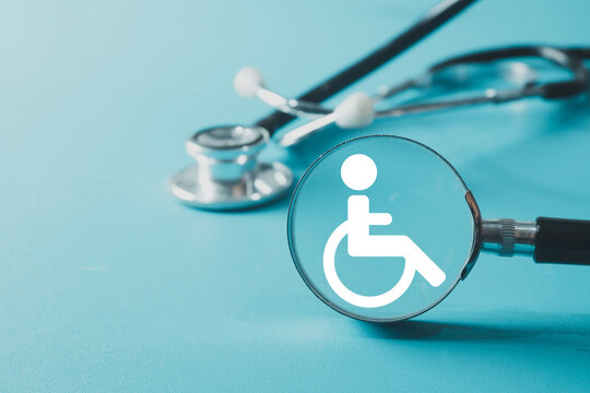 Healthcare for disabled people concept. A magnifying glass focuses on the wheelchair accessibility symbol with a stethoscope in background.Represents patient care,medical assessment, rehabilitation. - Powered by Adobe