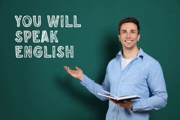 Teacher pointing at text You Will Speak English on green chalkboard. Language course