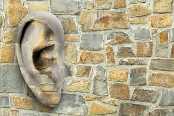 Human ear in stone wall, space for text. Eavesdropping, concept that even walls have ears