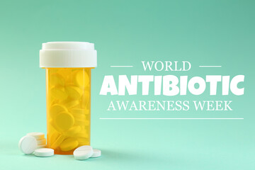 World antibiotic awareness week. Bottle and scattered pills on turquoise background