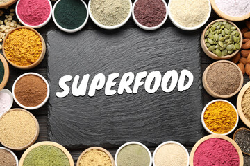 Superfood. Different powders, food products and slate board on wooden table, flat lay