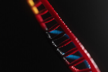 Glowing abstract DNA strand with vibrant colors in dark background
