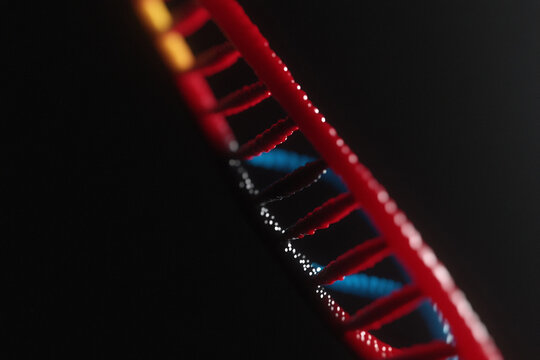 Glowing abstract DNA strand with vibrant colors in dark background