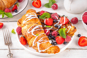Sweet breakfast croissant french toasts, with vanilla cream cheese glaze. Golden french toasts made from croissant buns, for tasty morning snack or lunch
