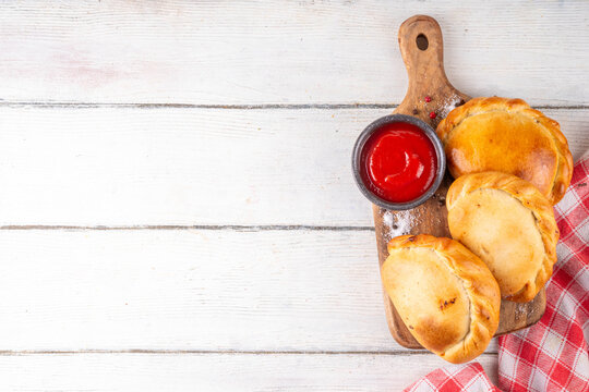 Homemade golden baked hand pies, with filling. Italian closed pizza calzone, empanadas, pierogies. Mini puff pastry or hand pies filled with sweet or savory stuffing. 