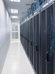 Modern IT server room with rows of black server racks in a high-tech data center environment,...