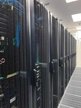 Modern IT server room with rows of black server racks in a high-tech data center environment, showcasing advanced technology, cyber security, and digital infrastructure.