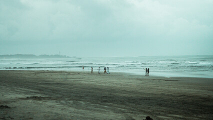 Atmospheric Beach Landscape on an Overcast Day with Dark Sand and Waves