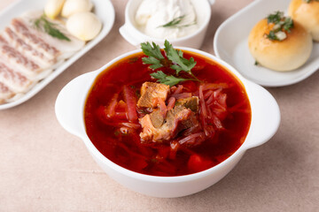 Borsch with pampushki (buns), sour cream, lard and garlic. Traditional Russian and Ukrainian soup with meat, beets, cabbage and potatoes. Close-up, selective focus.