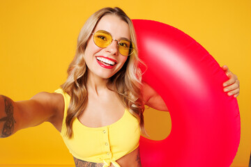 Close up young woman wear bikini swimsuit rest near hotel pool hold pink rubber ring do selfie shot...