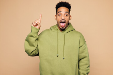 Young man of African American ethnicity wear green hoodie casual clothes holding index finger up...