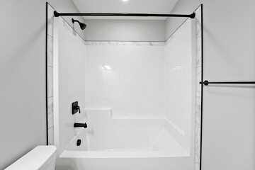 White bathroom with a black shower curtain and a black towel rack
