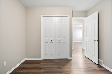 White bedroom with a white closet and a white door