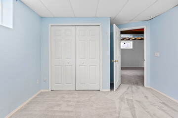 White bedroom with a white closet and a white door