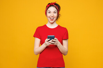 Young shocked surprised excited woman she wearing red t-shirt casual clothes hold in hand use...