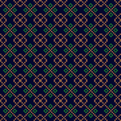 shows a green and brown cross-stitch fabric pattern on a dark blue background, featuring repeating geometric motifs, suitable for textiles and crafts with a folk aesthetic.