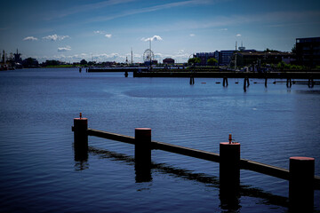 View over the calm waters of the large harbor with bollards, moorings, and the urban backdrop. On...