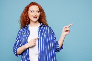 Young smiling happy ginger woman she wear shirt t-shirt casual clothes point index finger aside on...