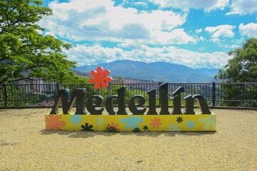 photograph of the sign that says I love Medellin, a black sign with a yellow base decorated with...
