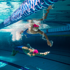Inner reflection. Collage with swimmers in dramatic underwater scene, moving in perfect opposition...