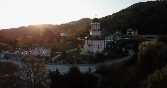 Pull-back drone footage of the Church "Healing Spring" Troianu at sunset in Ramnicu Valcea, Romania