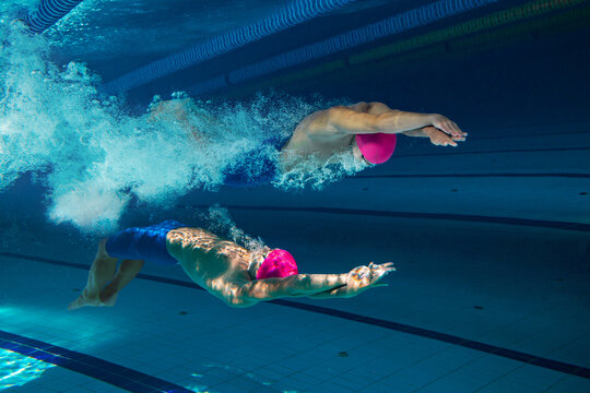 Collage with swimmers in dramatic underwater scene, moving in perfect opposition with explosive energy. Concept of self-competition and mindset, identity duality and internal struggle