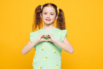 Little cheery fun cute kid child girl 8-9 years old wears green t-shirt showing shape heart with...