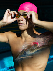 Male swimmer in pink swim cap adjusts his goggles, with a reflection of his underwater dive shown...