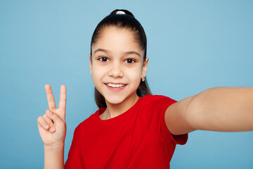 Close up little child kid girl 8-9 years old wears red t-shirt have fun doing selfie shot pov on...