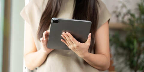 Digital Engagement. Young woman holding a tablet while browsing content.