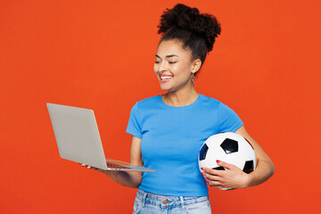 Young smiling IT woman fan wearing basic blue t-shirt cheer up support football sport team hold in...