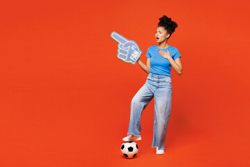 Full body young happy woman fan wearing blue t-shirt foam 1 glove finger up cheer up support...