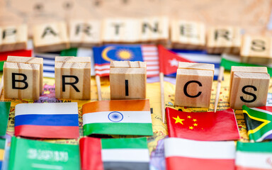  A Brics and Brics Partners concept with letter tiles and country flags on a world map.