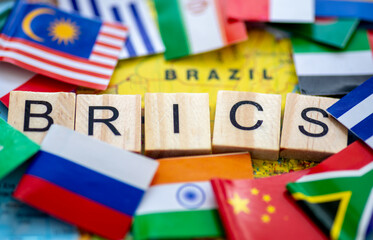 A Brics concept with wooden letter tiles and country flags on a map of Brazil.