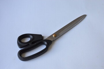 hand holding large metal scissors with black handle  ideal for themes like sewing, crafting,...